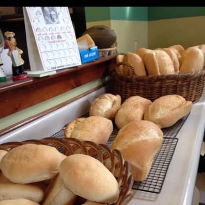 Baskets of fresh baked Italian bread rolls on the bakery counter