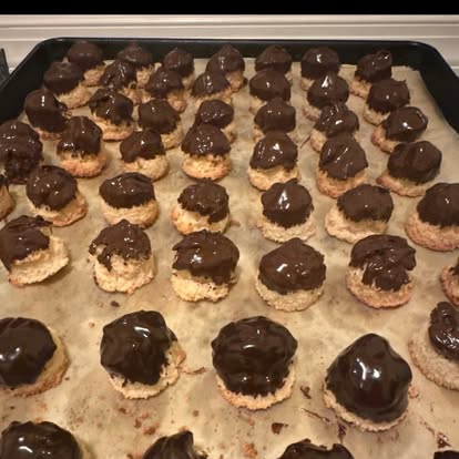Chocolate-topped cookies on a baking sheet