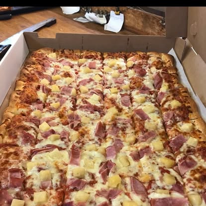 Ham and pineapple sheet pizza in a delivery box